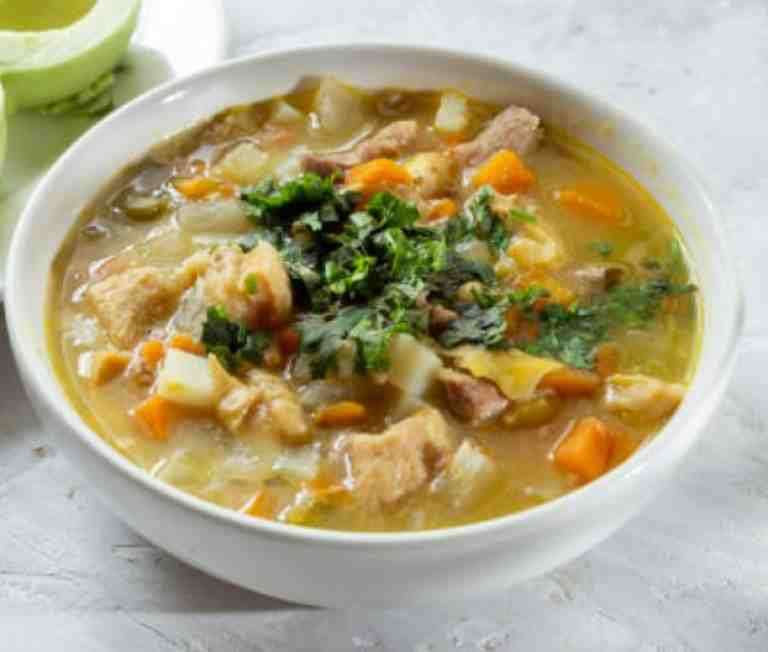 sopa de mondongo en una taza blanca