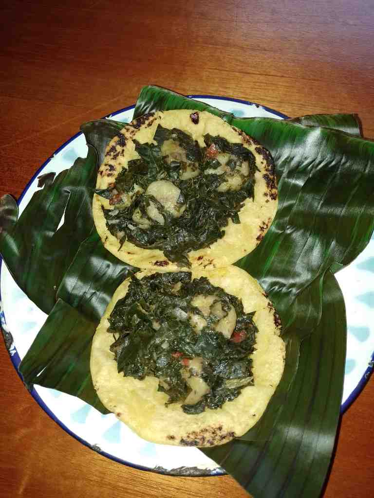 Picadillo servido sobre tortilla palmeada en una hoja de plátano sobre un plato de loza